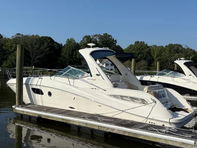 The Image of 2012 Sea Ray 350 Sundancer yacht docked at marina, surrounded by trees. - 2