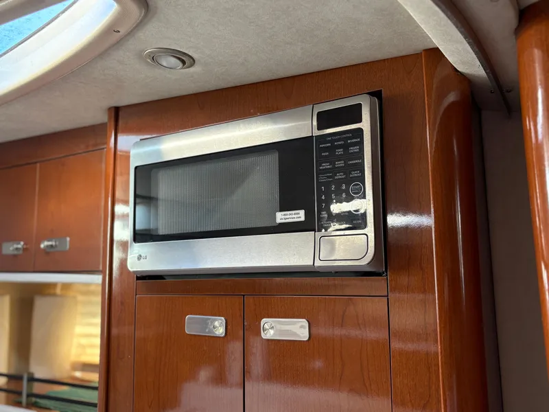 Slide: The Image of Microwave in 2012 Sea Ray 350 Sundancer yacht kitchen with wooden cabinetry. - 20