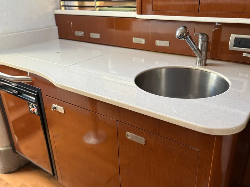 Slide: The Image of 2012 Sea Ray 350 Sundancer kitchen with sleek countertop and stainless steel sink. - 21