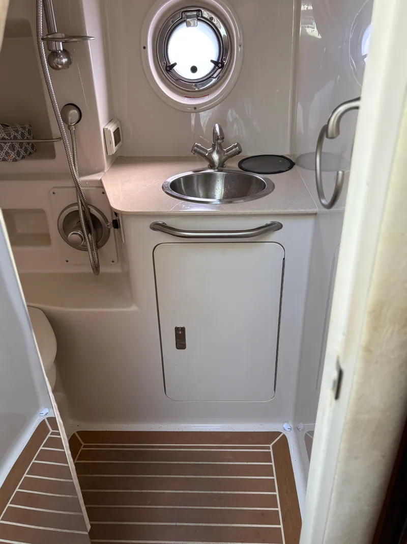 Slide: The Image of 2012 Sea Ray 350 Sundancer bathroom with sink, porthole, and shower. - 25
