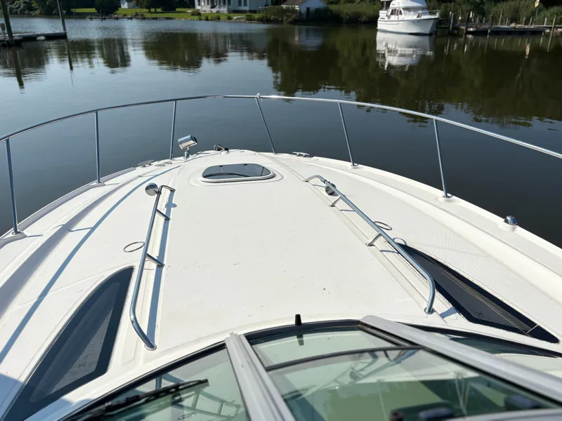 Slide: The Image of 2012 Sea Ray 350 Sundancer yacht on calm water, showcasing sleek deck design. - 4
