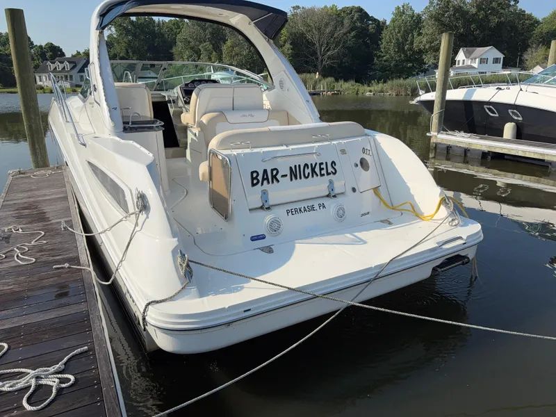 Slide: The Image of 2012 Sea Ray 350 Sundancer docked, rear view with "Bar-Nickels" name visible. - 5