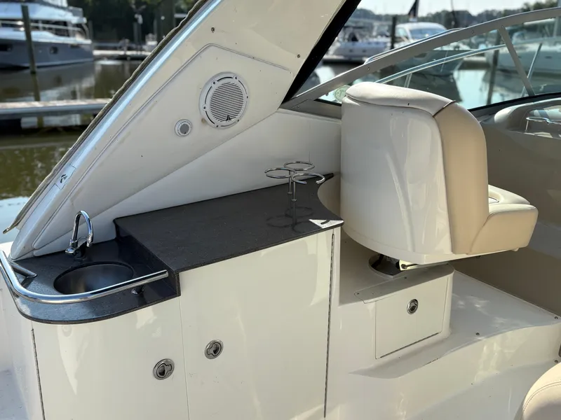Slide: The Image of 2012 Sea Ray 350 Sundancer cockpit with sink, seating, and cup holders. - 6