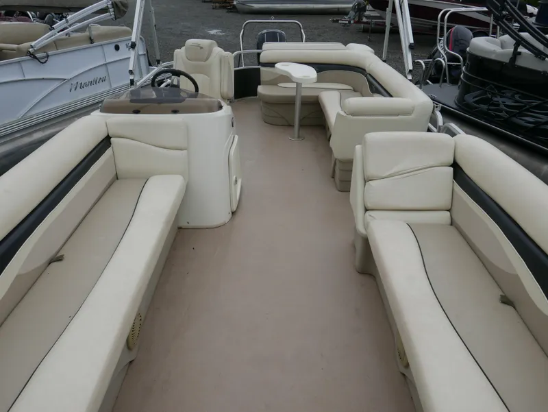 Slide: The Image of 2013 Bennington 22SLX pontoon boat interior with beige seating and steering console. - 3