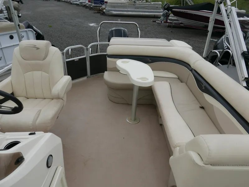 Slide: The Image of 2013 Bennington 22SLX pontoon boat interior with beige seating and table. - 9