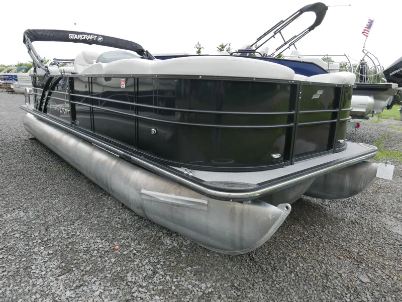 Slide: The Image of 2017 Starcraft SLS3 pontoon boat with black exterior on gravel surface. - 2