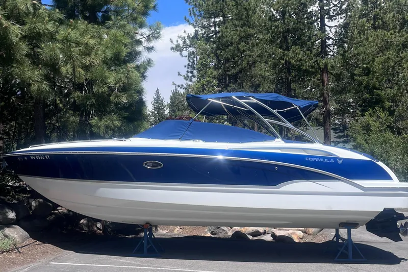 Slide: The Image of 2008 Formula 310 Bowrider boat on stands, surrounded by trees. - 0