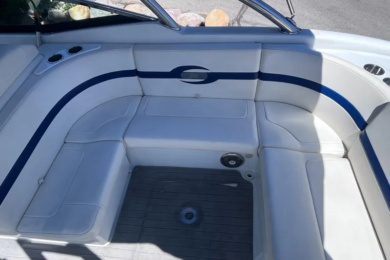 Slide: The Image of 2008 Formula 310 Bowrider interior with white and blue seating, cup holders, and deck flooring. - 13