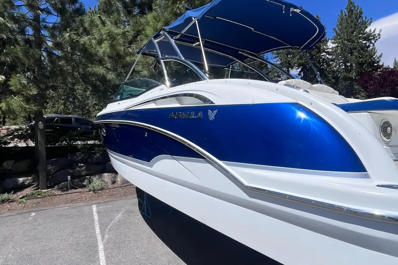 Slide: The Image of 2008 Formula 310 Bowrider boat with blue and white exterior, parked outdoors. - 4