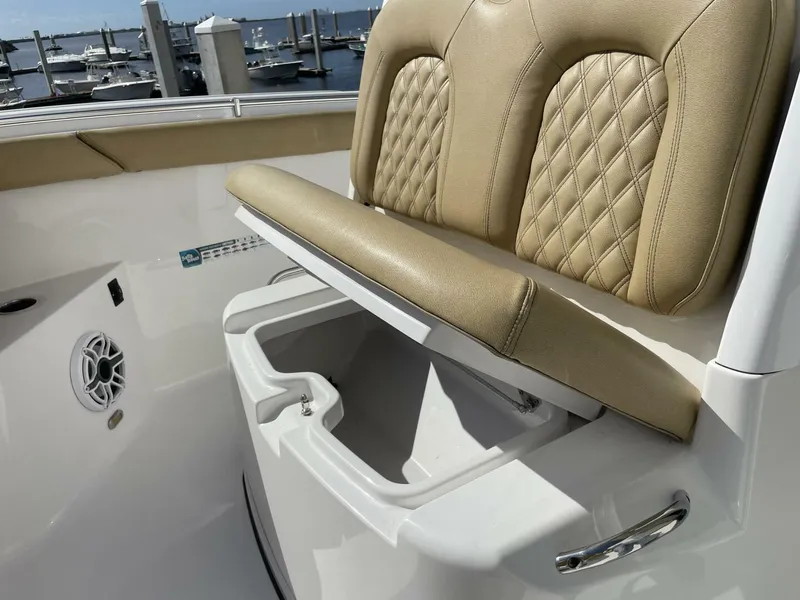 Slide: The Image of 2021 Sportsman 302 OPEN boat with tan cushioned seating and storage compartment. - 13