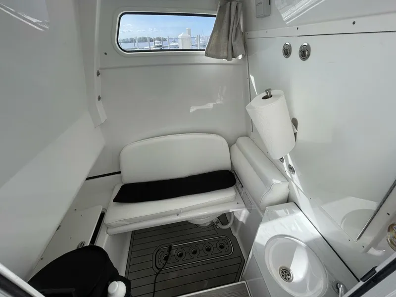 Slide: The Image of 2021 Sportsman 302 OPEN boat interior with seating, sink, and window view. - 14