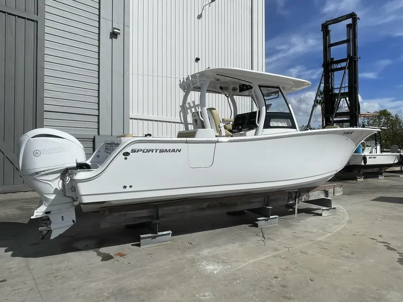 Slide: The Image of 2021 Sportsman 302 OPEN boat with Yamaha engine, displayed outdoors on stands. - 2