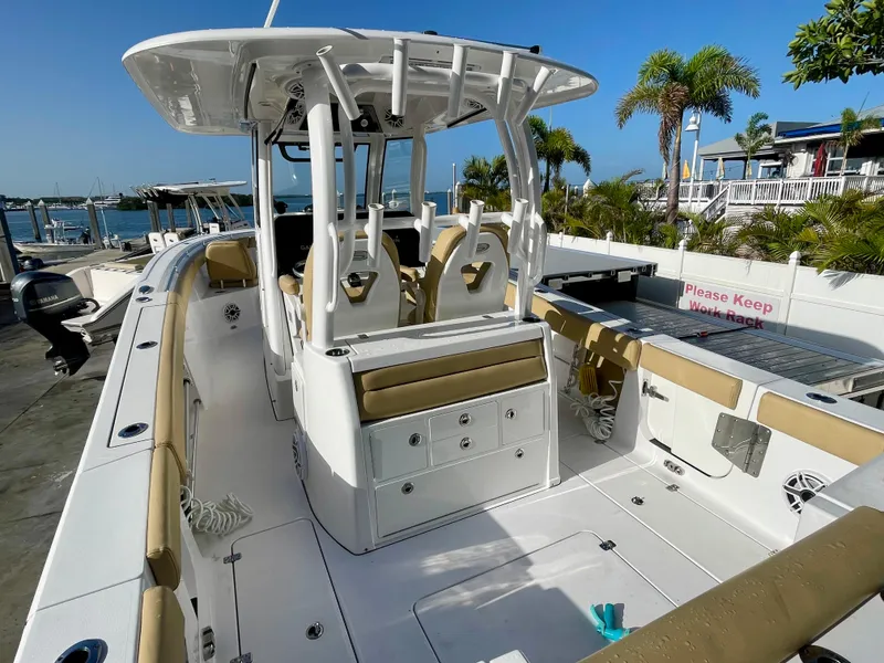 Slide: The Image of 2021 Sportsman 302 OPEN boat with tan seating, docked near palm trees and waterfront. - 20