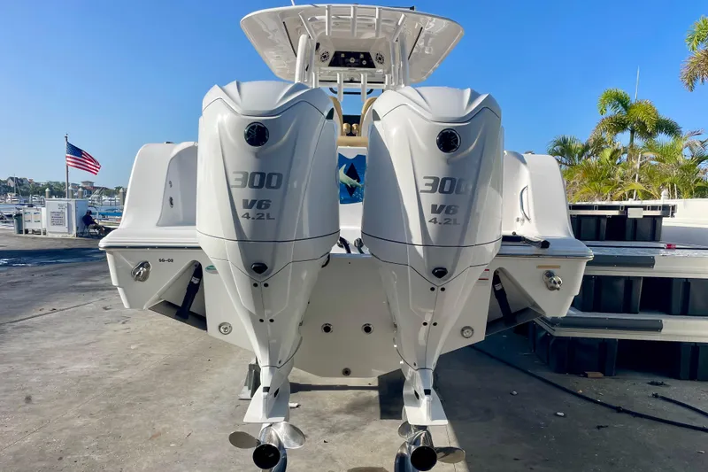 Slide: The Image of 2021 Sportsman 302 OPEN boat with dual 300 V6 engines, docked near American flag. - 25