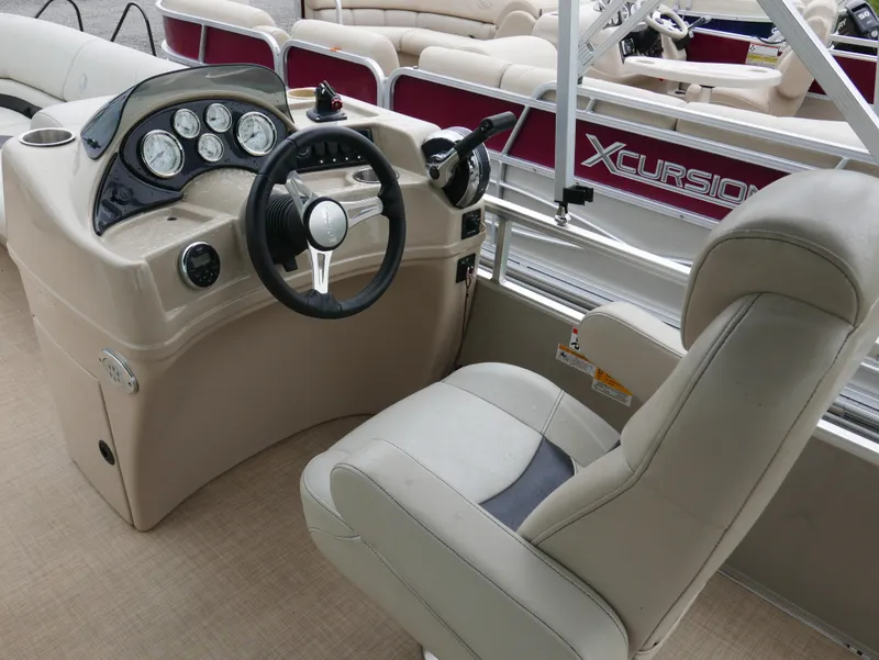 Slide: The Image of Captain's seat and helm of a 2015 Lowe SS230 pontoon boat, featuring a steering wheel and gauges. - 10
