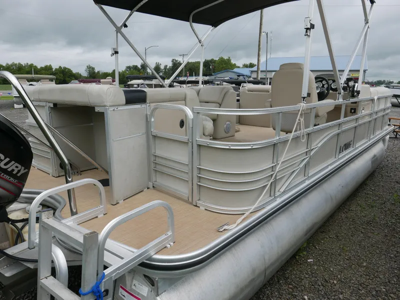 Slide: The Image of 2015 Lowe SS230 pontoon boat with canopy and seating, parked on gravel. - 4