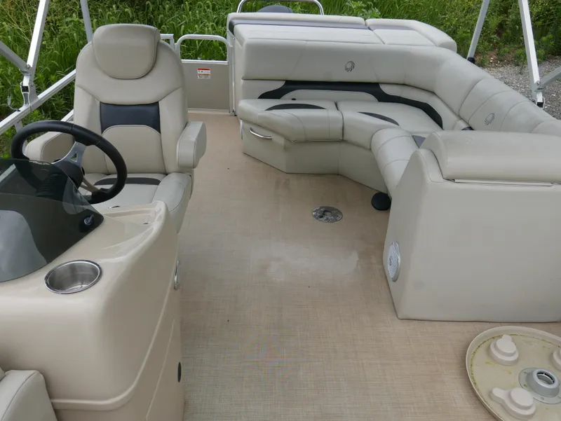 Slide: The Image of 2015 Lowe SS230 pontoon boat interior with beige seating and steering console. - 9
