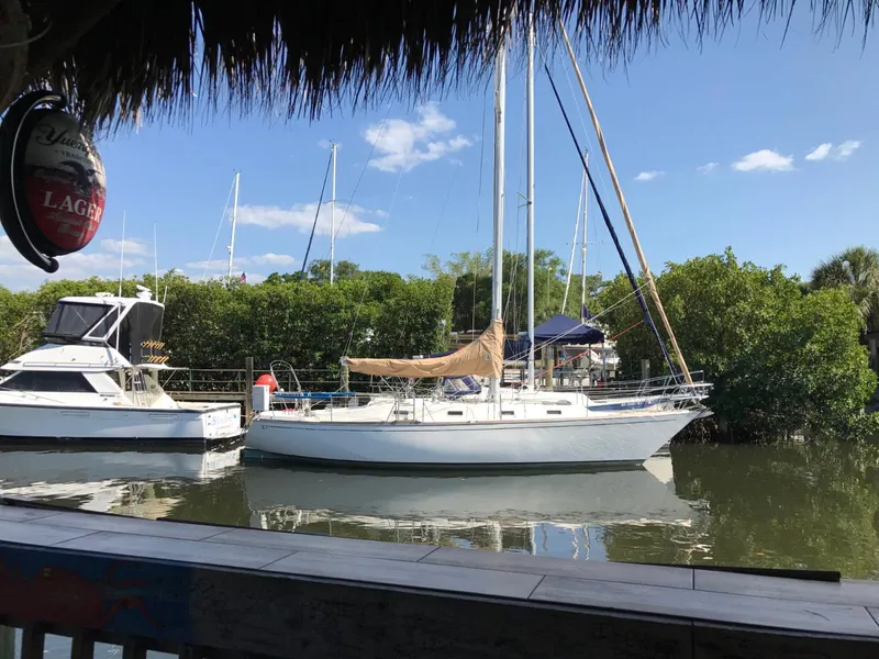 Slide: The Image of 1981 Tartan 37 sloop docked at marina, covered mainsail, calm water. - 1