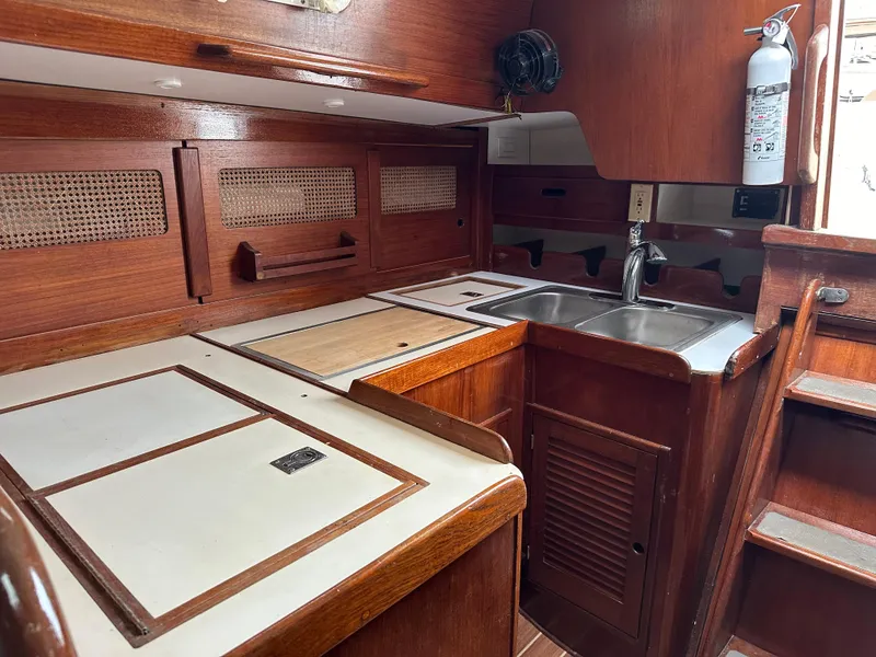 Slide: The Image of 1981 Tartan 37 sloop interior kitchen with wooden cabinetry and stainless steel sink. - 11