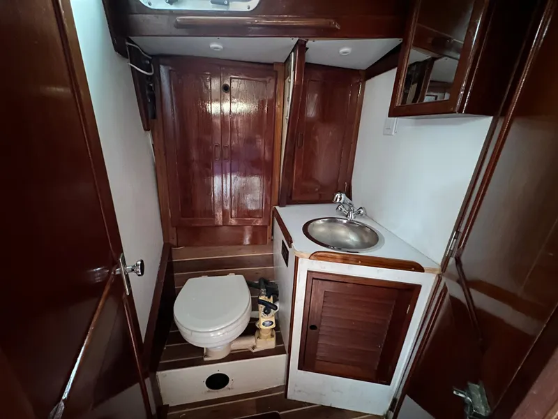 Slide: The Image of 1981 Tartan 37 sloop bathroom with wooden cabinetry, sink, and toilet. - 16