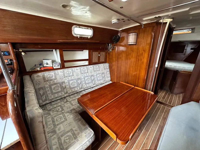 Slide: The Image of Interior of 1981 Tartan 37 sloop with wooden table and patterned seating. - 17