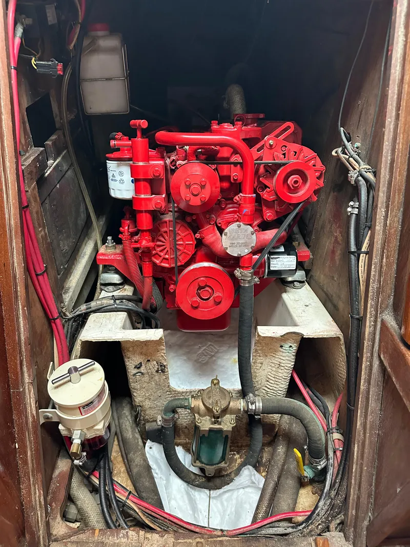 Slide: The Image of Engine compartment of a 1981 Tartan 37 sloop, featuring a red marine engine. - 19