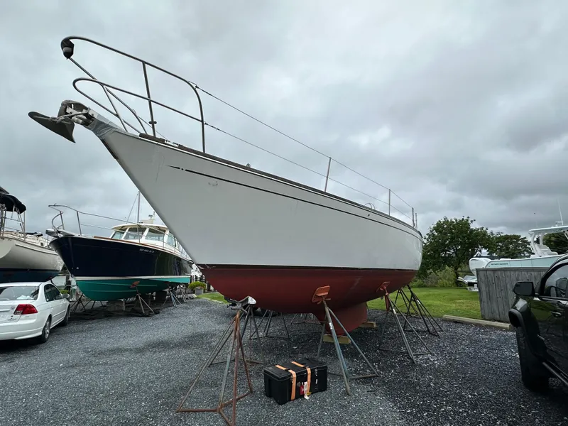 Slide: The Image of 1981 Tartan 37 sloop on stands, overcast sky, boatyard setting. - 4