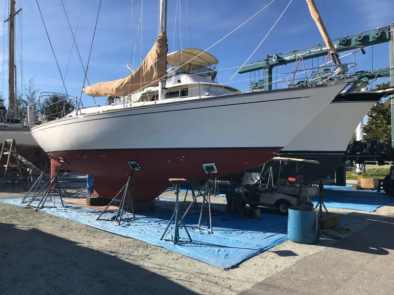 Slide: The Image of 1981 Tartan 37 sloop sailboat on stands in a boatyard under clear blue sky. - 5