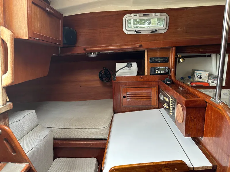 Slide: The Image of 1981 Tartan 37 sloop interior with navigation station, wood cabinetry, and cushioned seating. - 9