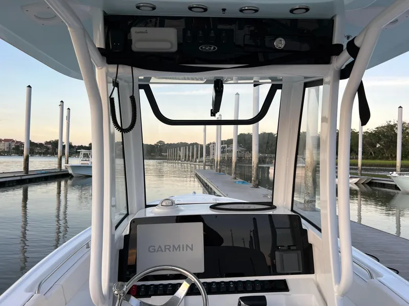 Slide: The Image of 2024 Sea Hunt Ultra 239 SE boat dashboard with Garmin navigation at a marina. - 17