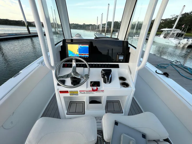 Slide: The Image of 2024 Sea Hunt Ultra 239 SE boat dashboard with steering wheel and navigation display. - 19