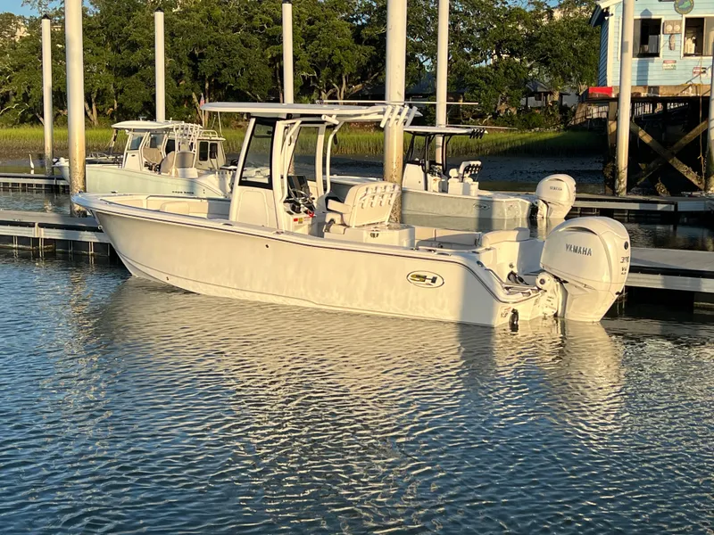 Slide: The Image of 2024 Sea Hunt Ultra 239 SE boat docked in calm waters. - 2