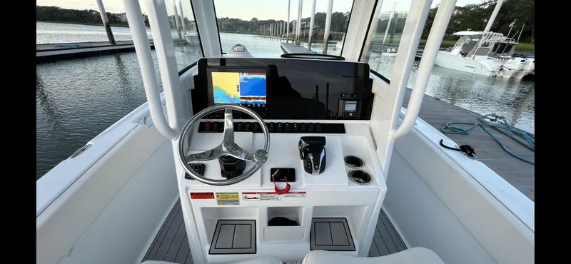 Slide: The Image of 2024 Sea Hunt Ultra 239 SE boat dashboard with steering wheel and navigation display. - 20