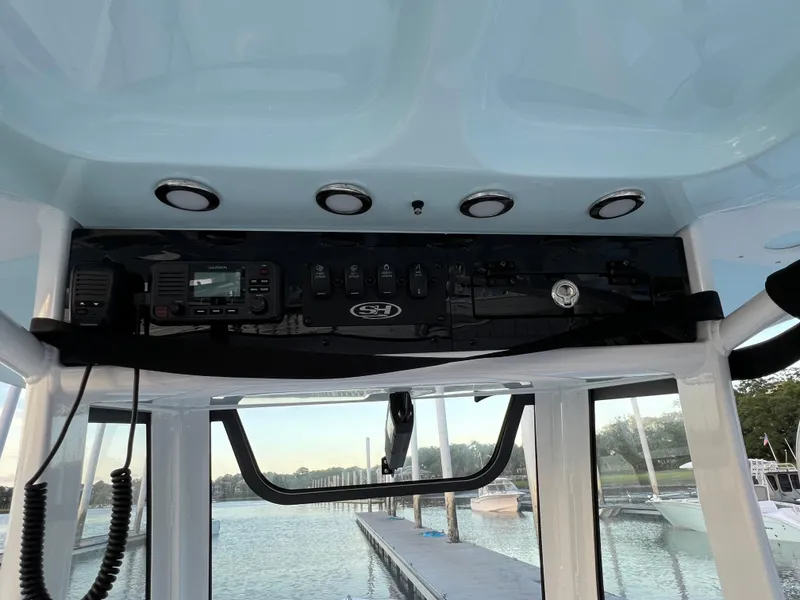 Slide: The Image of 2024 Sea Hunt Ultra 239 SE boat console with electronic controls and dock view. - 21