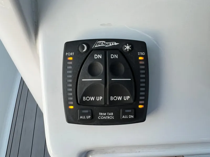 Slide: The Image of 2024 Sea Hunt Ultra 239 SE trim tab control panel with bow adjustment buttons. - 23