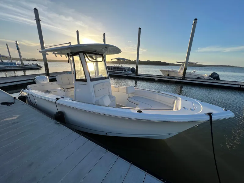 Slide: The Image of 2024 Sea Hunt Ultra 239 SE boat docked at sunset, showcasing sleek design and spacious deck. - 30