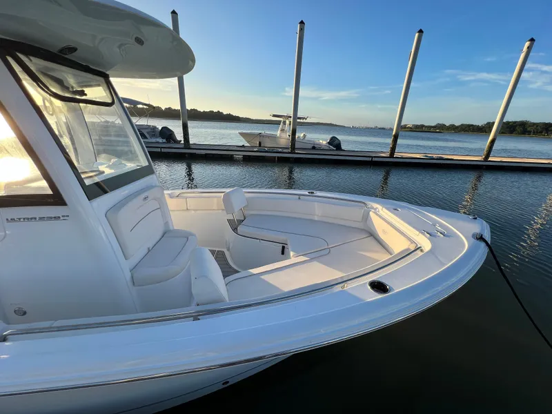 Slide: The Image of 2024 Sea Hunt Ultra 239 SE boat docked on calm water at sunset. - 31