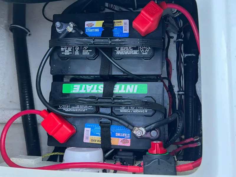 Slide: The Image of Battery compartment of 2024 Sea Hunt Ultra 239 SE with Interstate batteries and wiring. - 35