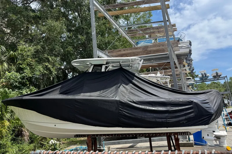 Slide: The Image of 2024 Sea Hunt Ultra 239 SE boat covered in black tarp, stored outdoors. - 39