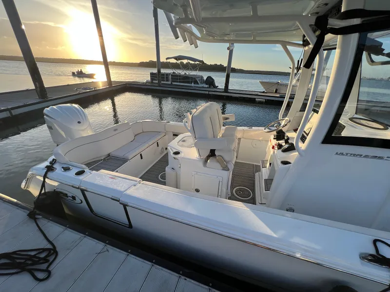 Slide: The Image of 2024 Sea Hunt Ultra 239 SE boat docked at sunset, showcasing sleek design and spacious interior. - 7