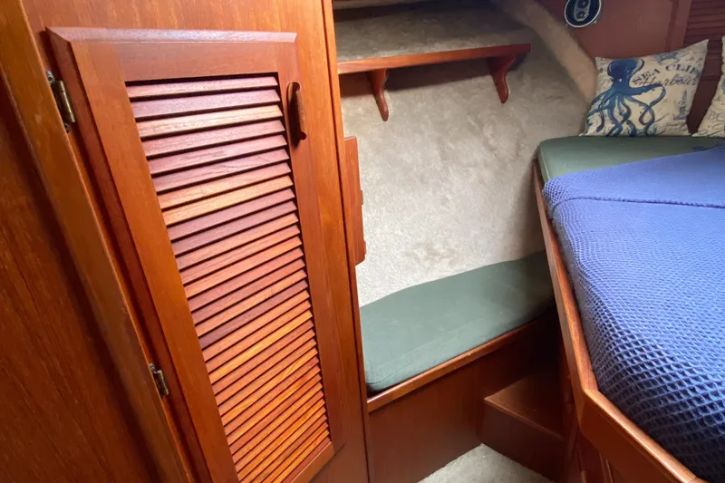 Slide: The Image of 1984 Tollycraft 34 Convertible Sedan cabin interior with wooden cabinetry and cozy bedding. - 15