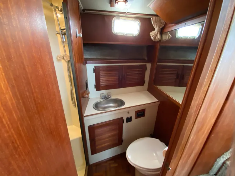 Slide: The Image of 1984 Tollycraft 34 Convertible Sedan bathroom with wood cabinetry, sink, and toilet. - 16