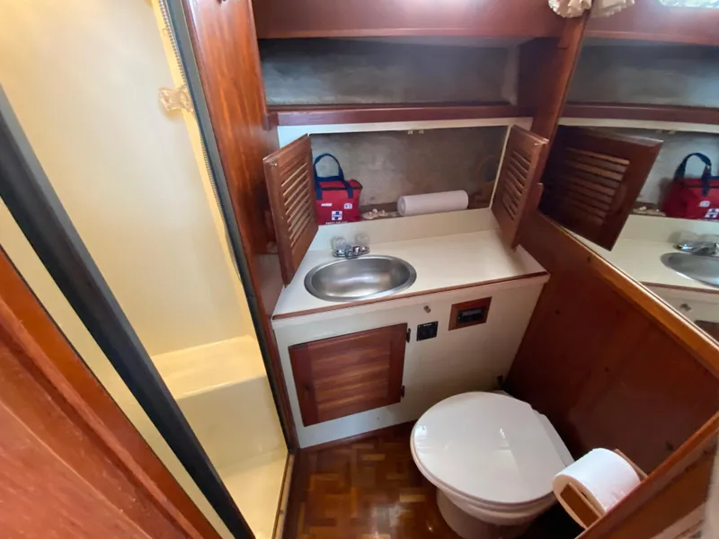 Slide: The Image of 1984 Tollycraft 34 Convertible Sedan bathroom with sink, toilet, and wooden cabinetry. - 18