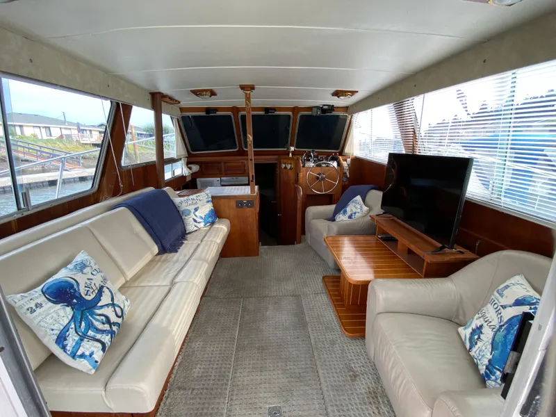 Slide: The Image of 1984 Tollycraft 34 Convertible Sedan interior with plush seating and nautical decor. - 2