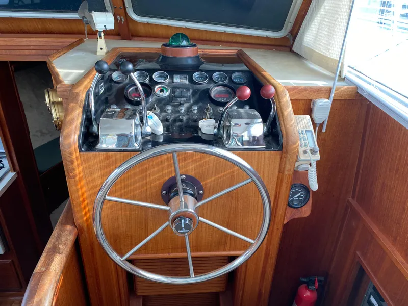 Slide: The Image of 1984 Tollycraft 34 Convertible Sedan helm with steering wheel and control panel. - 20