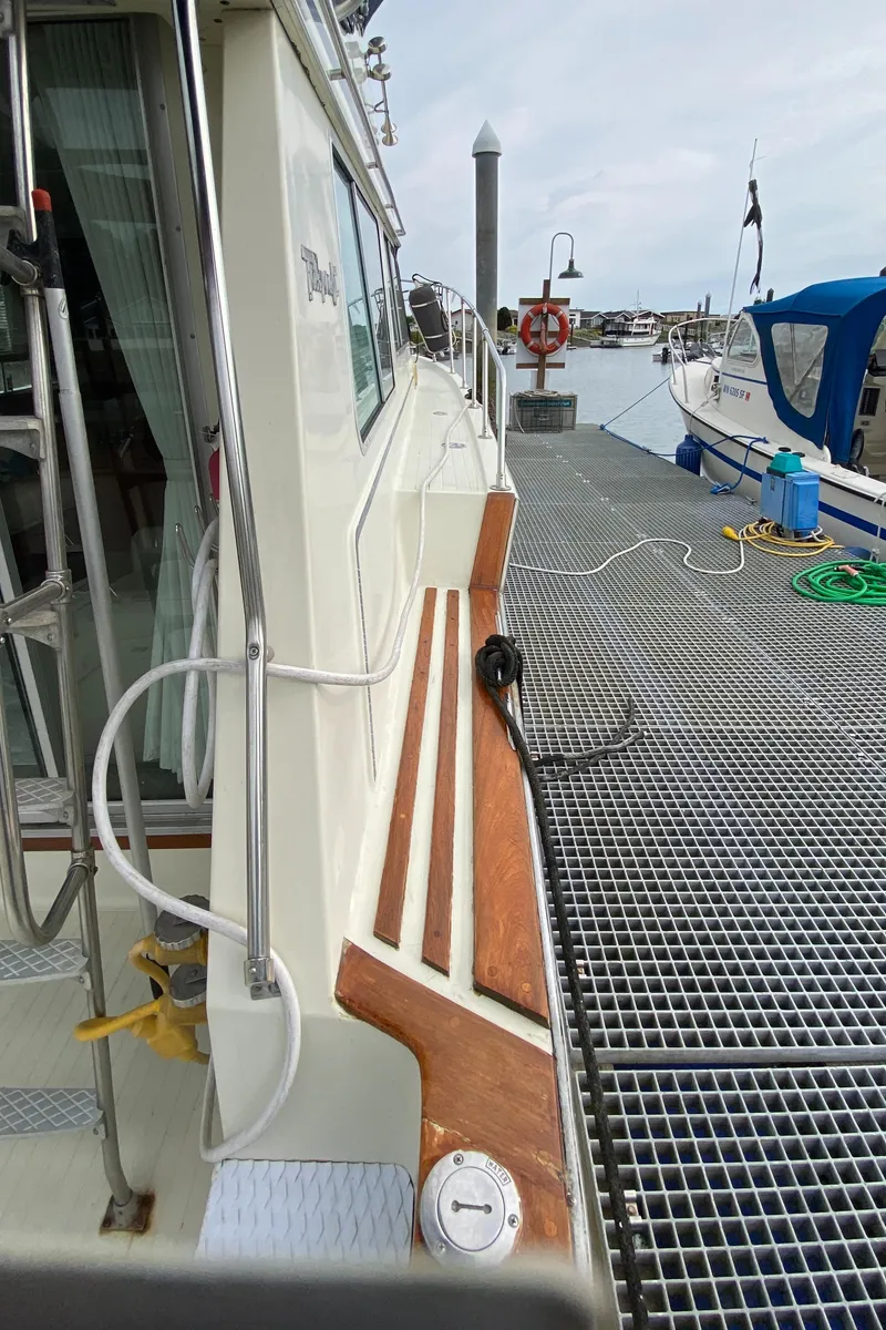 Slide: The Image of 1984 Tollycraft 34 Convertible Sedan docked at marina, side view with wooden accents. - 36