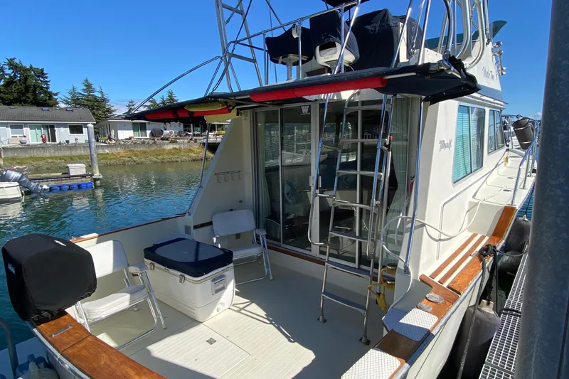 Slide: The Image of 1984 Tollycraft 34 Convertible Sedan docked, featuring spacious deck and ladder access. - 38