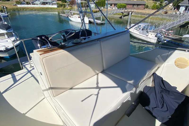 Slide: The Image of 1984 Tollycraft 34 Convertible Sedan boat with cushioned seating on deck, docked in marina. - 42