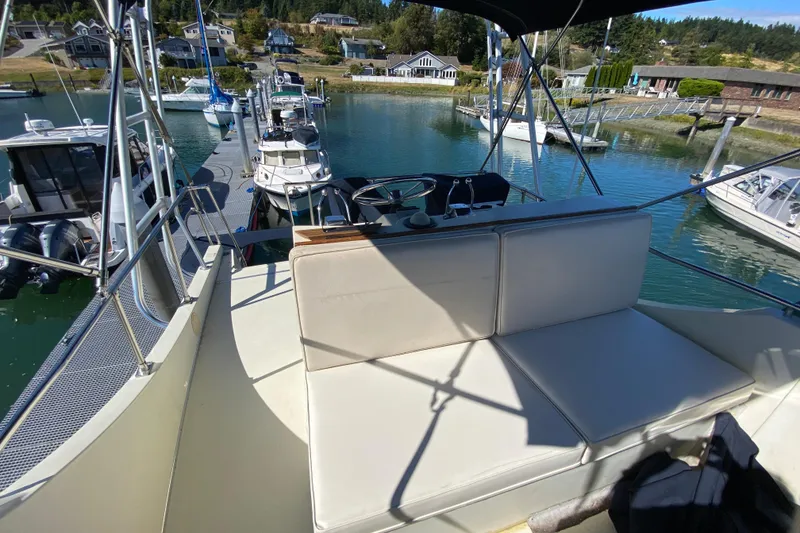 Slide: The Image of 1984 Tollycraft 34 Convertible Sedan at marina, featuring spacious seating and scenic waterfront view. - 53