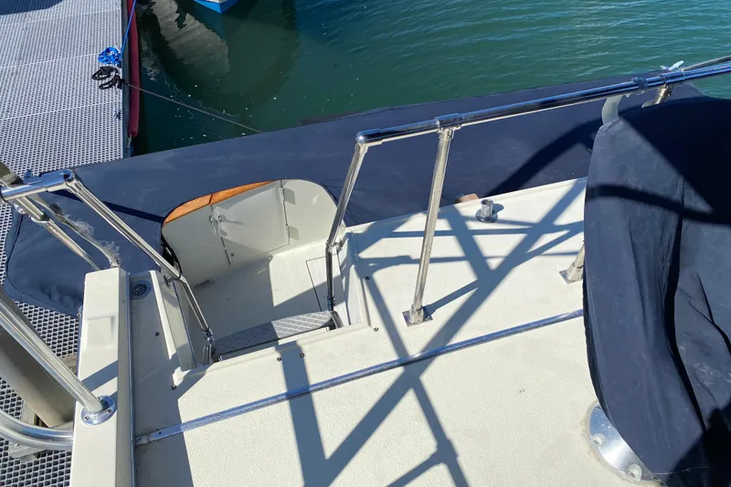 Slide: The Image of 1984 Tollycraft 34 Convertible Sedan boat deck with railing and dock view. - 54